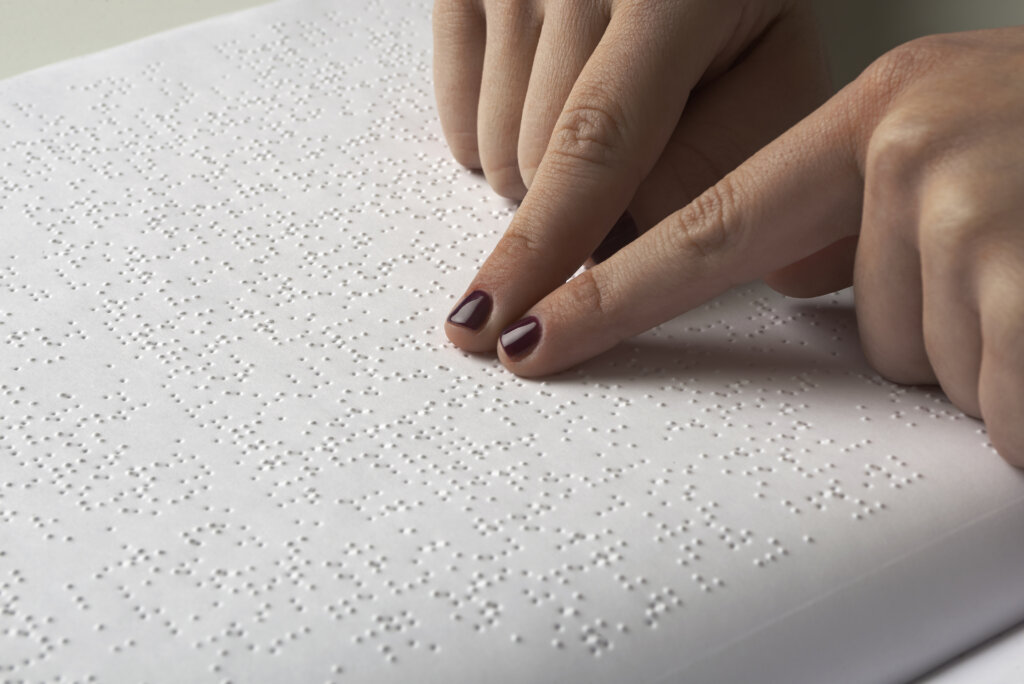 Blind woman reading text in braille language